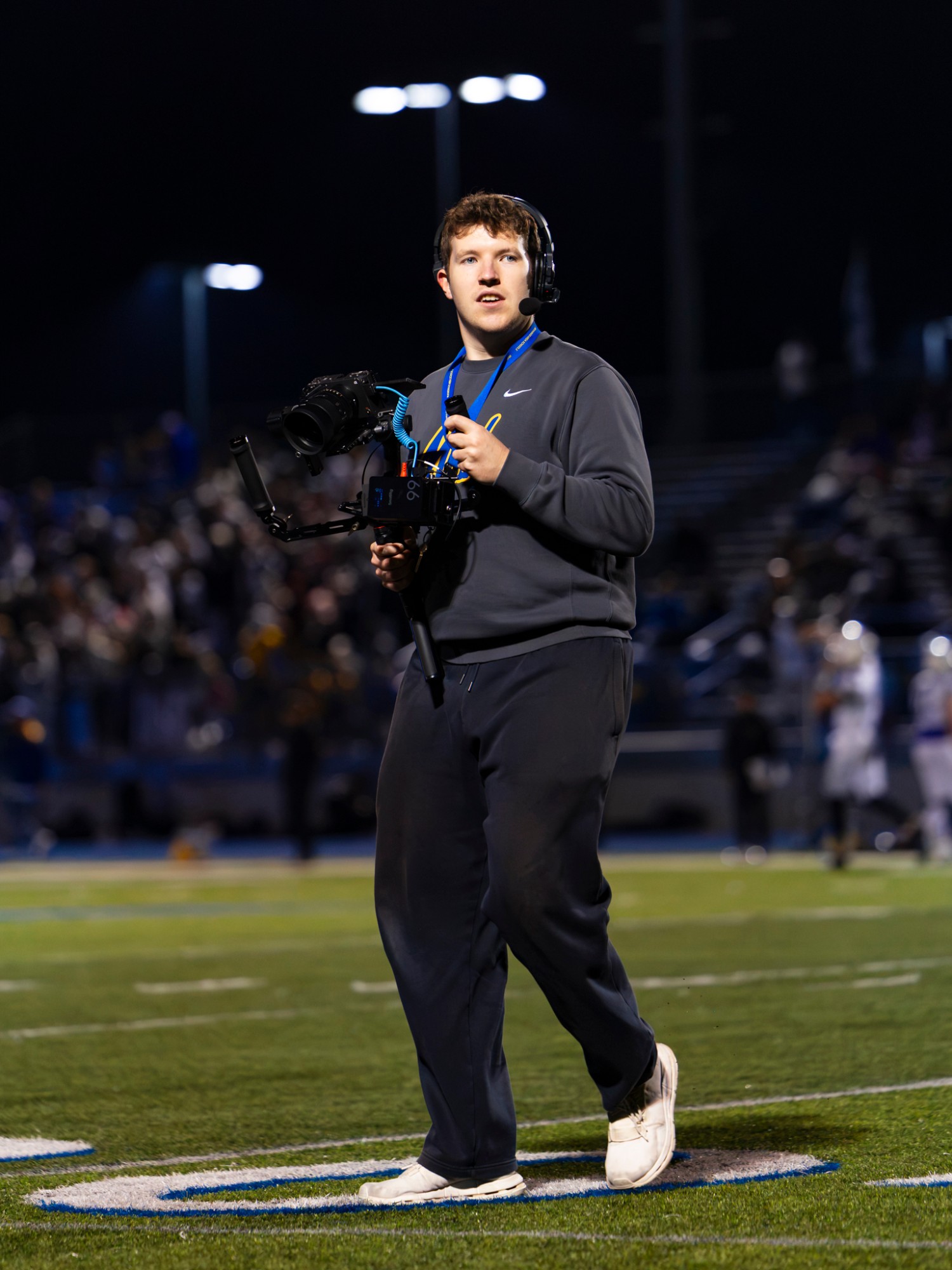 Ethan Jaworski walking the field with a gimbal under the stadium lights