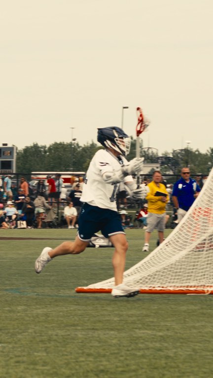 A Fluid Lacrosse player shooting at a summer tournament