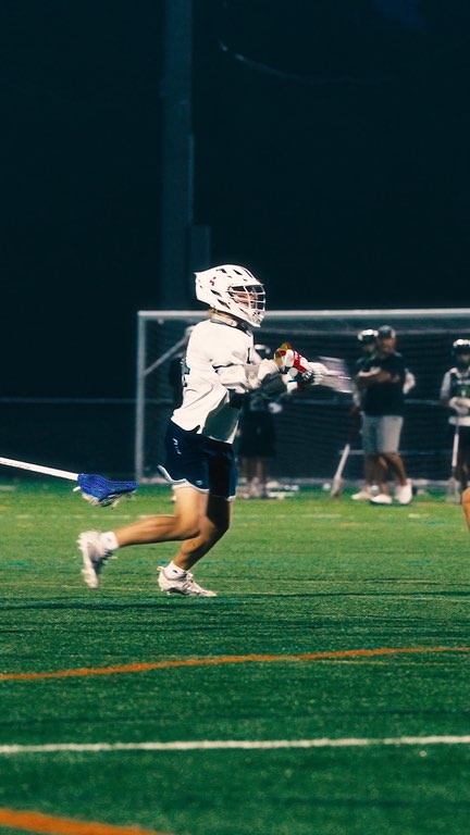 A Fluid Lacrosse player carrying the ball at the IMLCA showcase